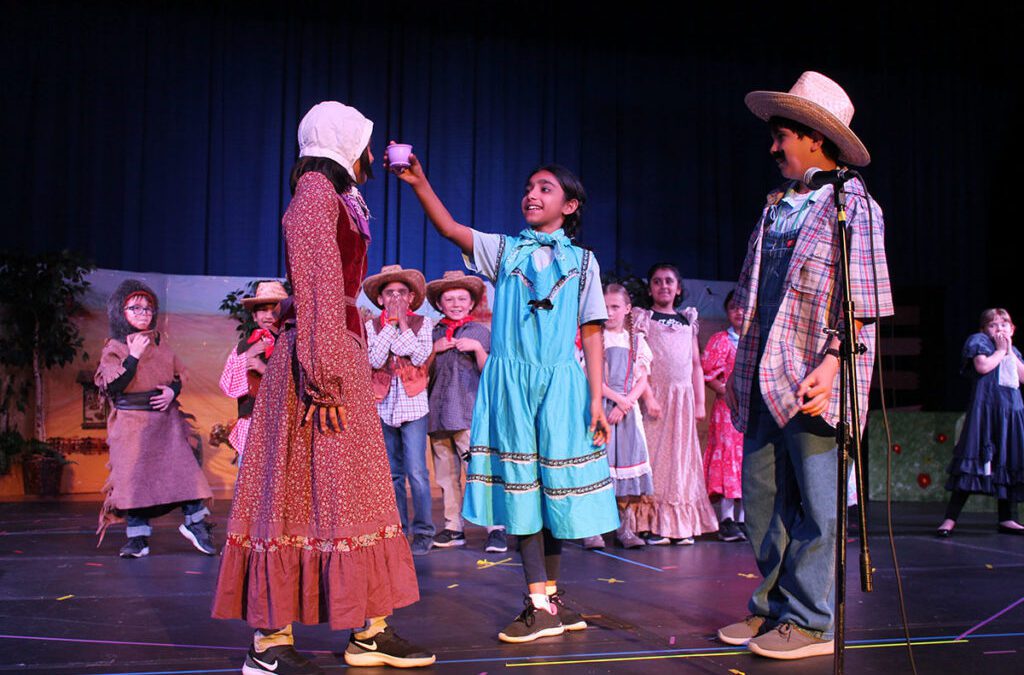 Group of students performing drama on stage
